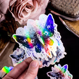 Moths and Butterflies Fantasy Holographic sticker set of 8 pieces, with natural witchy elements. Step into a realm of enchantment with our meticulously handcrafted set of 8 stickers, featuring ethereal moths and butterflies in a dark fantasy style.