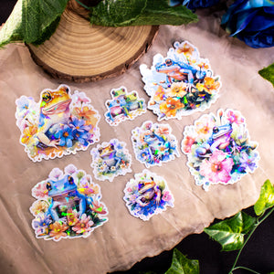 Pastel Frogs Holographic Handmade Sticker Set of 8, natural flower elements and cute style. Dive into a world of whimsy with our handcrafted "Pastel Frogs" sticker set. Each of the 8 stickers is a testament to originality, handcrafted on high-quality adhesive paper with a delightful holographic effect.